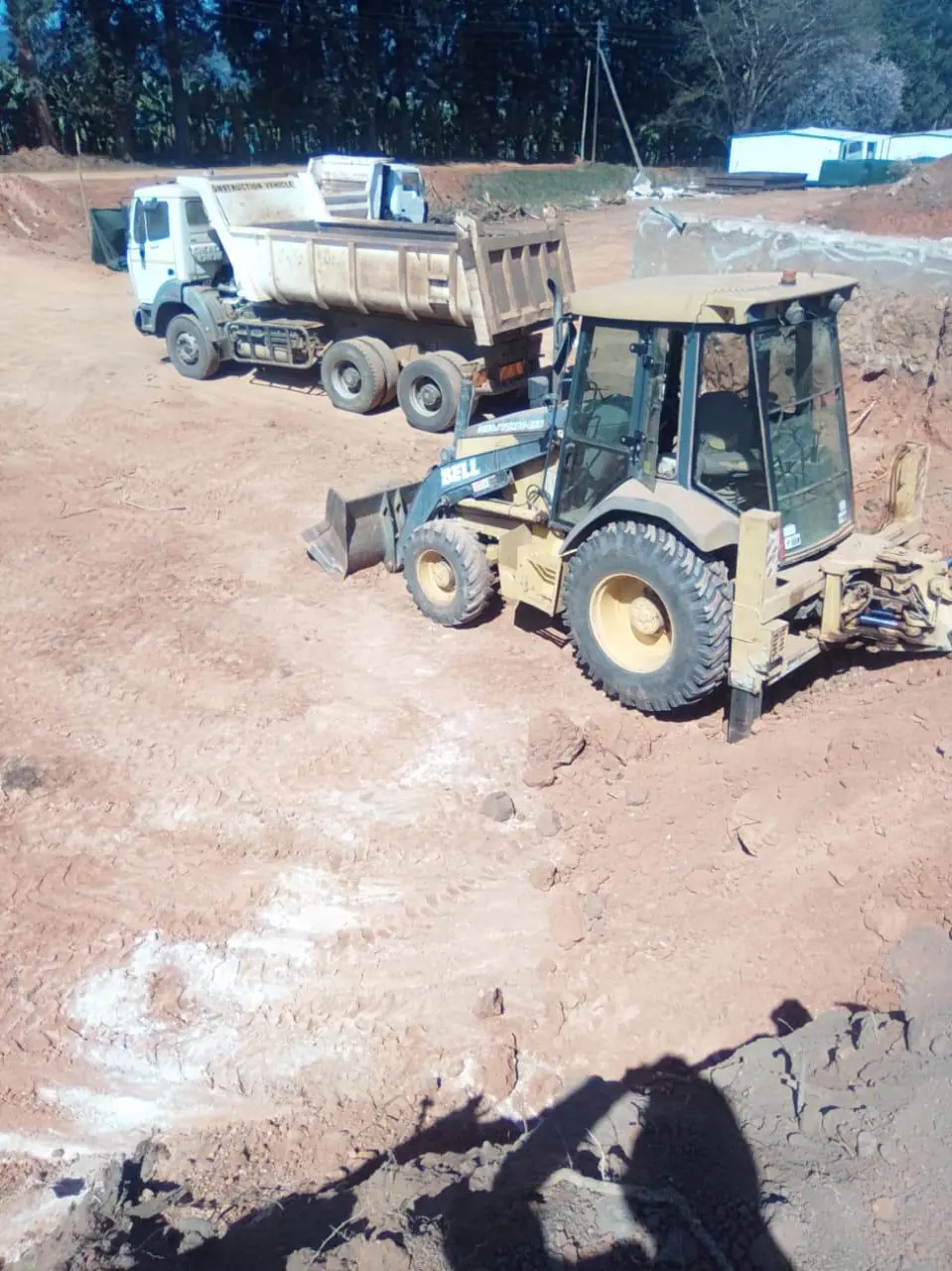 Dump truck and TLB working at a construction site